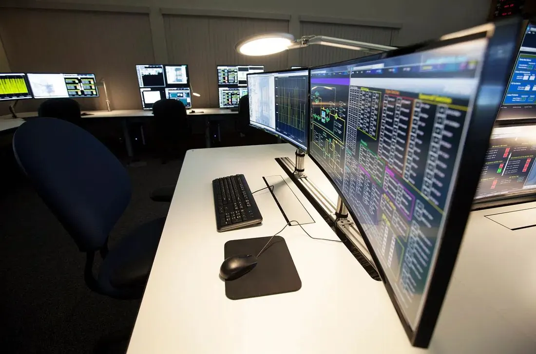 Centro de monitoreo con varias pantallas y computadores
